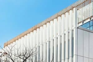 A white building with Szucha external wall cladding and a blue sky.