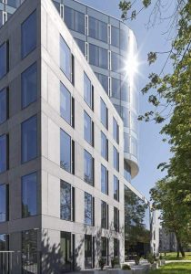 A modern office building with large windows and a grassy area designed by Contexture Group.